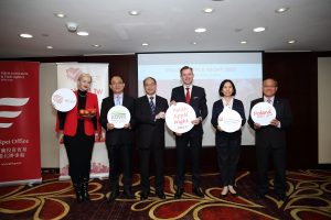 Zdjęcie przedstawia wydarzenie „Polish Apple Night”. Podczas gali przedstawiciele z Biura Polskiego w Tajpej oraz Zagranicznego Biura Handlowego Polskiej Agencji Inwestycji i Handlu w Tajpej promują polskie jabłka wśród osób reprezentujących instytucje państwowe, firmy importowe, stowarzyszenia branżowe i sieci handlowe oraz media branżowe na Tajwanie. Na stołach znajdują się polskie jabłka oraz materiały promocyjne. Zaproszeni goście pozują do zdjęć z napisem Poland tastes good.