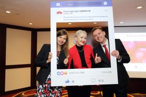 Zdjęcie przedstawia wydarzenie „Polish Apple Night”. Podczas gali przedstawiciele z Biura Polskiego w Tajpej oraz Zagranicznego Biura Handlowego Polskiej Agencji Inwestycji i Handlu w Tajpej promują polskie jabłka wśród osób reprezentujących instytucje państwowe, firmy importowe, stowarzyszenia branżowe i sieci handlowe oraz media branżowe na Tajwanie. Na stołach znajdują się polskie jabłka oraz materiały promocyjne. Zaproszeni goście pozują do zdjęć z napisem Poland tastes good.